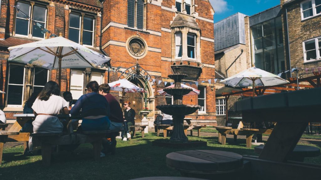 The Orator garden Courtyard in the centre of Cambridge behind the round church with outside tables and people eating and drinking